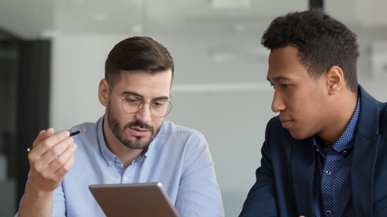 Diverse mates working on startup project use tablet discuss online apps, caucasian company representative meet with client showing explain offering presenting new services on electronic gadget concept
